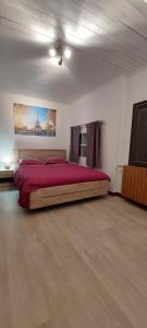 - une chambre avec un grand lit et une couverture rouge dans l'établissement Belle maison de 140 m2, à Villard-de-Lans