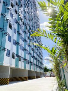 マンダウエ・シティにある2BR condo at banilad cebu 650のヤシの木が前に生えている高い建物