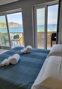 a bed with towels on it with a view of the ocean at La Finestra sul Mare Modern Apartment in Giardini Naxos