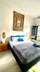 a bedroom with a large bed with blue pillows at HOTEL RENASCI PALOMINO in Palomino