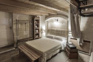 a bedroom with a bed with a bench in it at Il Tempo Ritrovato in Matera