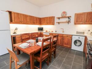 cocina con mesa de madera y armarios de madera en The Grange en Whitby