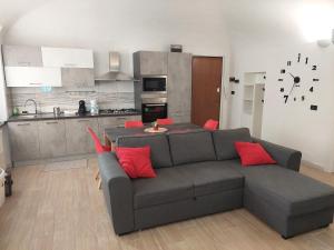 ein Wohnzimmer mit einem Sofa und einer Küche in der Unterkunft Novi Outlet Apartment in Novi Ligure