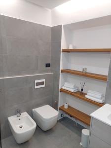 a bathroom with a white toilet and a sink at Novi Outlet Apartment in Novi Ligure +15 photos