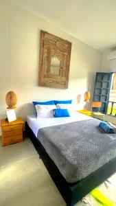 a bedroom with a large bed with blue pillows at HOTEL RENASCI PALOMINO in Palomino