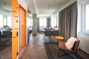 - un salon avec un canapé et une chaise dans l'établissement LOGINN Hotel Offenbach, à Offenbach-sur-le-Main