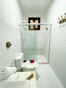 y baño blanco con aseo y ducha. en Casa Melhor Vista do Morro en Morro de São Paulo