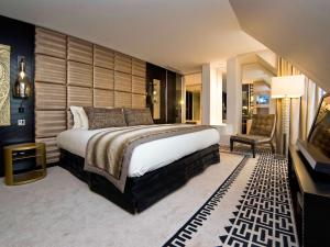 a bedroom with a large bed and a chair at Sofitel Paris Le Faubourg in Paris