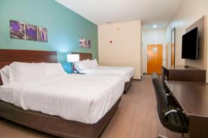Habitación de hotel con 2 camas y TV de pantalla plana. en Sleep Inn & Suites, en Tuscaloosa
