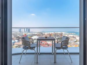 - un balcon avec vue doté de 2 chaises et d'une table dans l'établissement Rixos Premium Qetaifan Island North, à Doha