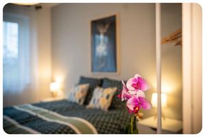 ein Schlafzimmer mit einem Bett und einer Blume in einer Vase in der Unterkunft La Chaumière Alsacienne 