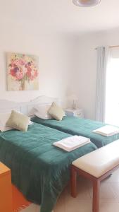 ラゴスにあるVila apartamentos Estrelaのベッドルーム1室(ベッド1台、緑の毛布付)