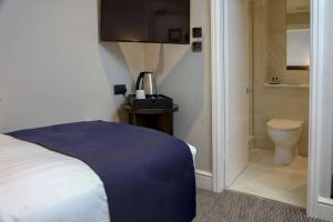 a hotel room with a bed and a toilet at Trafford Hall Hotel Manchester, Trademark Collection by Wyndham in Manchester