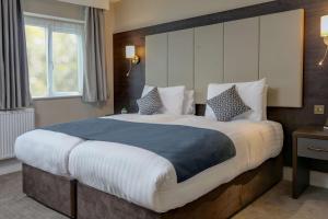 a bedroom with a large bed in a room at Trafford Hall Hotel Manchester, Trademark Collection by Wyndham in Manchester