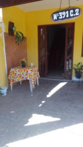 a table in front of a building with a sign at Hospedaria Meu lar in Rio das Ostras