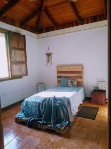 1 dormitorio con 1 cama en una habitación con techos de madera en Casa Qi Boho B&B en Cabuya