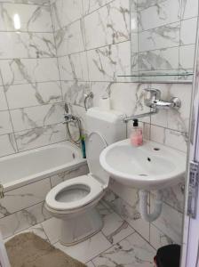 een witte badkamer met een toilet en een wastafel bij Motel BI in Bijeljina