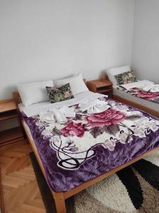 two beds in a room with flowers on them at Motel BI in Bijeljina