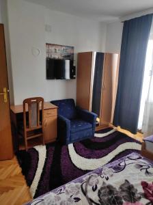 a living room with a blue couch and a kitchen at Motel BI in Bijeljina