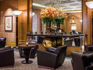 a lobby with a large table with chairs and flowers at Sofitel New York in New York