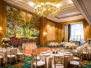 a ballroom with tables and chairs and a chandelier at Sofitel New York in New York