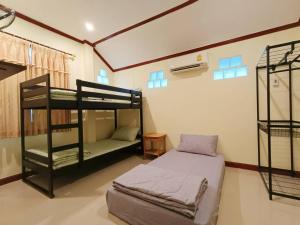 Cette chambre comprend deux lits superposés et un lit. dans l'établissement Forever House, à Ko Muk