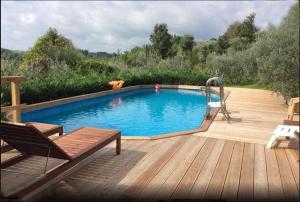 una piscina su una terrazza in legno con panchina di Farmhouse with pool in the Chianti a Montefiridolfi