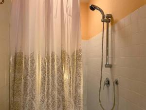 e bagno con doccia con tenda bianca. di Farmhouse with pool in the Chianti a Montefiridolfi
