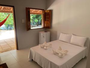 a bedroom with a bed with two flowers on it at POUSADA PARAÍSO CULTURAL in Barreirinhas +81 photos