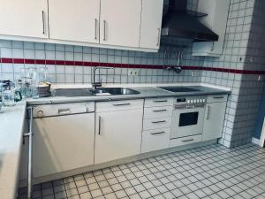 a white kitchen with a sink and a stove at Personalunterkunft nahe Euregio-Klinik Nordhorn 1 in Nordhorn