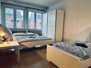 a room with two beds and a large window at Personalunterkunft nahe Euregio-Klinik Nordhorn 1 in Nordhorn