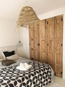 a bedroom with a black and white bed and a chandelier at Ronda Center Apartments with Pool in Ronda