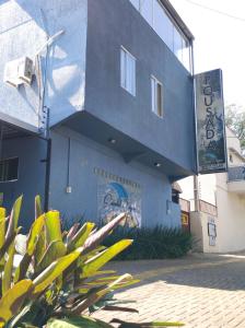 a blue building with a sign on the side of it at Pousada Quedas D'água in Foz do Iguaçu