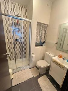 uma casa de banho com um chuveiro, um WC e um lavatório. em Kolbe Residence em St. Paul's Bay