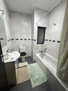 uma casa de banho branca com um lavatório e um WC em Kolbe Residence em St. Paul's Bay