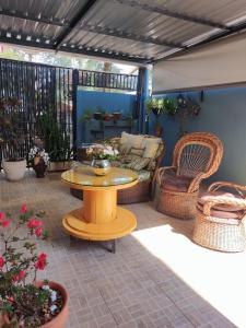 a patio with a table and wicker chairs at Pousada Quedas D'água in Foz do Iguaçu