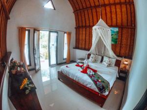 a bedroom with a bed in a room with windows at Meket Bungalows in Nusa Penida