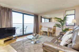 a living room with a couch and a television at Seafront Quay West Apartments in Cowes