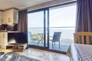 a bedroom with a large window with a view of the ocean at Seafront Quay West Apartments in Cowes