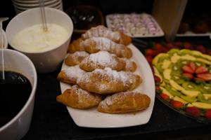 a table with a plate of donuts and a plate of fruit at Mai İnci Otel in Antalya