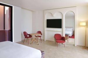BenguerirDoubletree By Hilton Ben Guerir Hotel & Residences的一间带床、桌椅的酒店房间