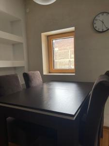 mesa de comedor con sillas y reloj en la pared en Double bedroom apartment in Belgrade en Belgrado