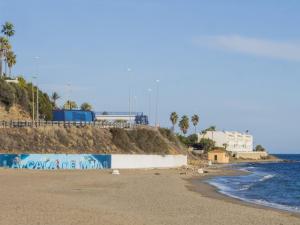 a beach with graffiti on it next to the ocean at Cubo's Beach Side Apartment at La Cala in La Cala de Mijas