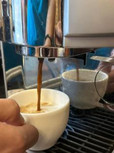 a person is pouring coffee into a bowl at Mai İnci Otel in Antalya
