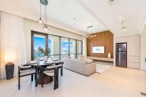 a living room with a table and a couch at FAM Living - Vida Residences Stylish 2BR Creekfront Charm in Dubai