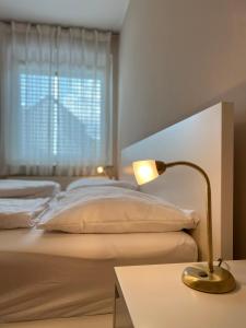 a bedroom with a bed and a table with a lamp at Der Landsitz in Klagenfurt