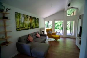 sala de estar con sofá y silla en Ferienhaus Robinson Crusoe Schwarzkittelpfad 80, en Waldbrunn