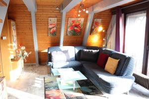 ein Wohnzimmer mit einem Sofa und einem Tisch in der Unterkunft Ferienhaus Winnetou Schwarzkittelpfad 85 in Waldbrunn