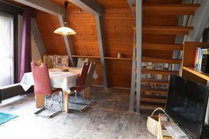 ein Esszimmer mit einem Tisch und Stühlen sowie einem TV in der Unterkunft Ferienhaus Winnetou Schwarzkittelpfad 85 in Waldbrunn