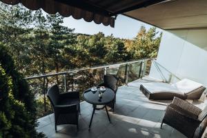 een patio met stoelen en een tafel op een balkon bij Vanagupės Terasa in Palanga